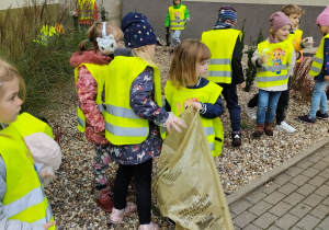 Dzieci zbierają śmieci na klombach